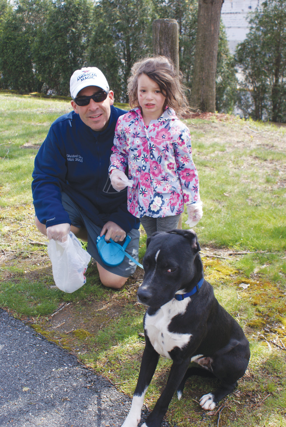 A FAMILY MATTER: Cranston Police Capt. Vin McAteer, his daughter, 3-year-old Helena, and their dog, Ranger, share a moment during the recent cleanup.
